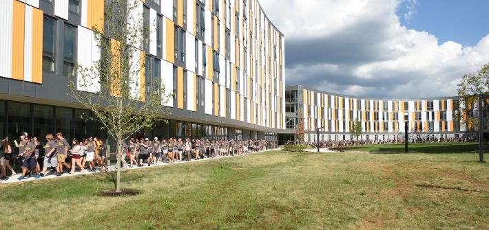 Freshmen students tour the outside of Holly Pointe Commons residence hall.