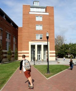 student skateboarding toward Rowan library