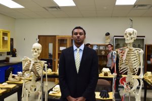 student stands with skeleton