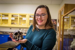 student holds skull mold