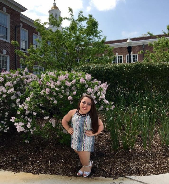 Mackenzie Trush stands in front of flowers at Rowan