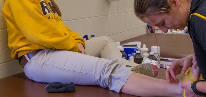 athletic training major works on a student's ankle
