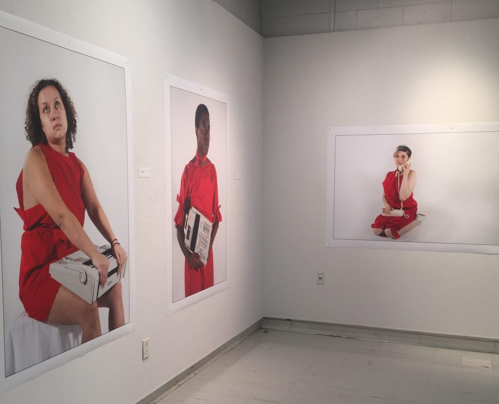 white walls, oversized photos of women wearing red clothing