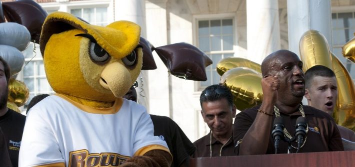 Rowan mascot on stage in front of Bunce to welcome students, surrounded by students