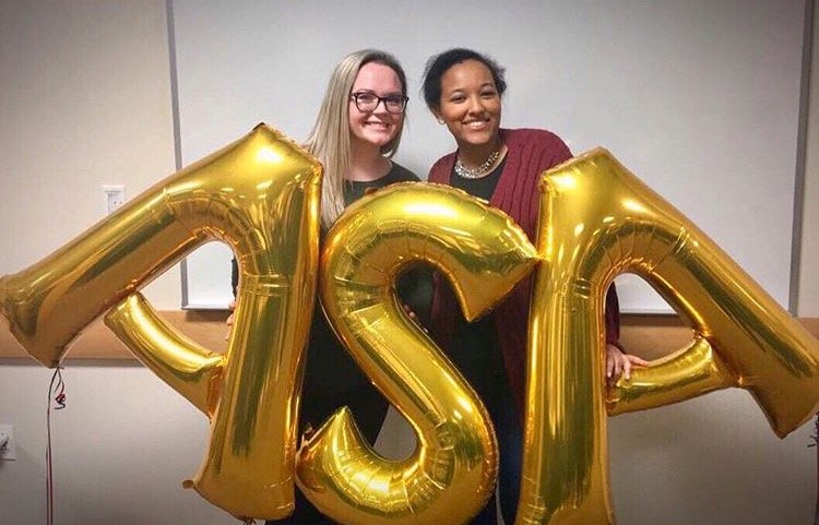 Mackenna holds gold balloons that spell the initials of her sorority, ASA.