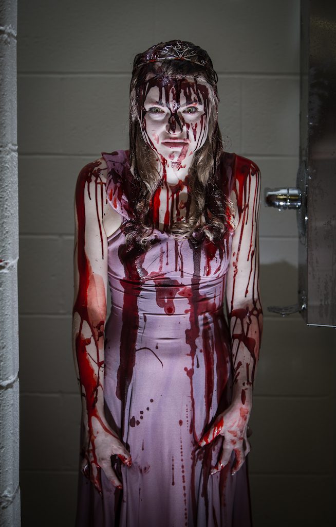 bloodied actress in a shower stall for Carrie: The Musical