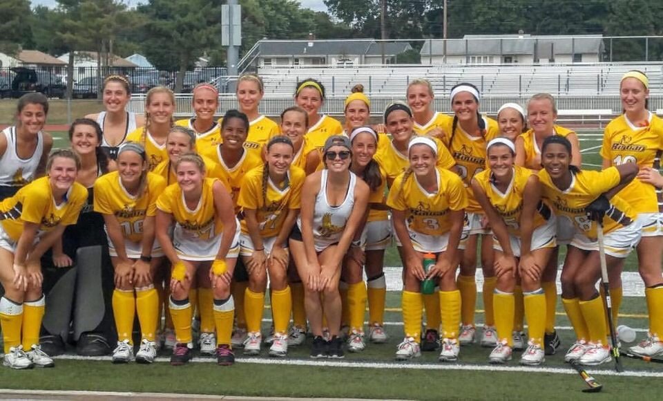 field hockey team photo, with 27 smiling faces all wearing yellow Rowan athletic jerseys