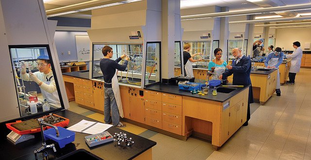 students handle lab materials in an organic chemistry class lab.
