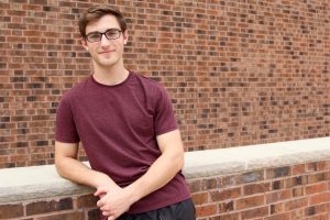 Brian leaning on brick wall at the Student Center at Rowan University