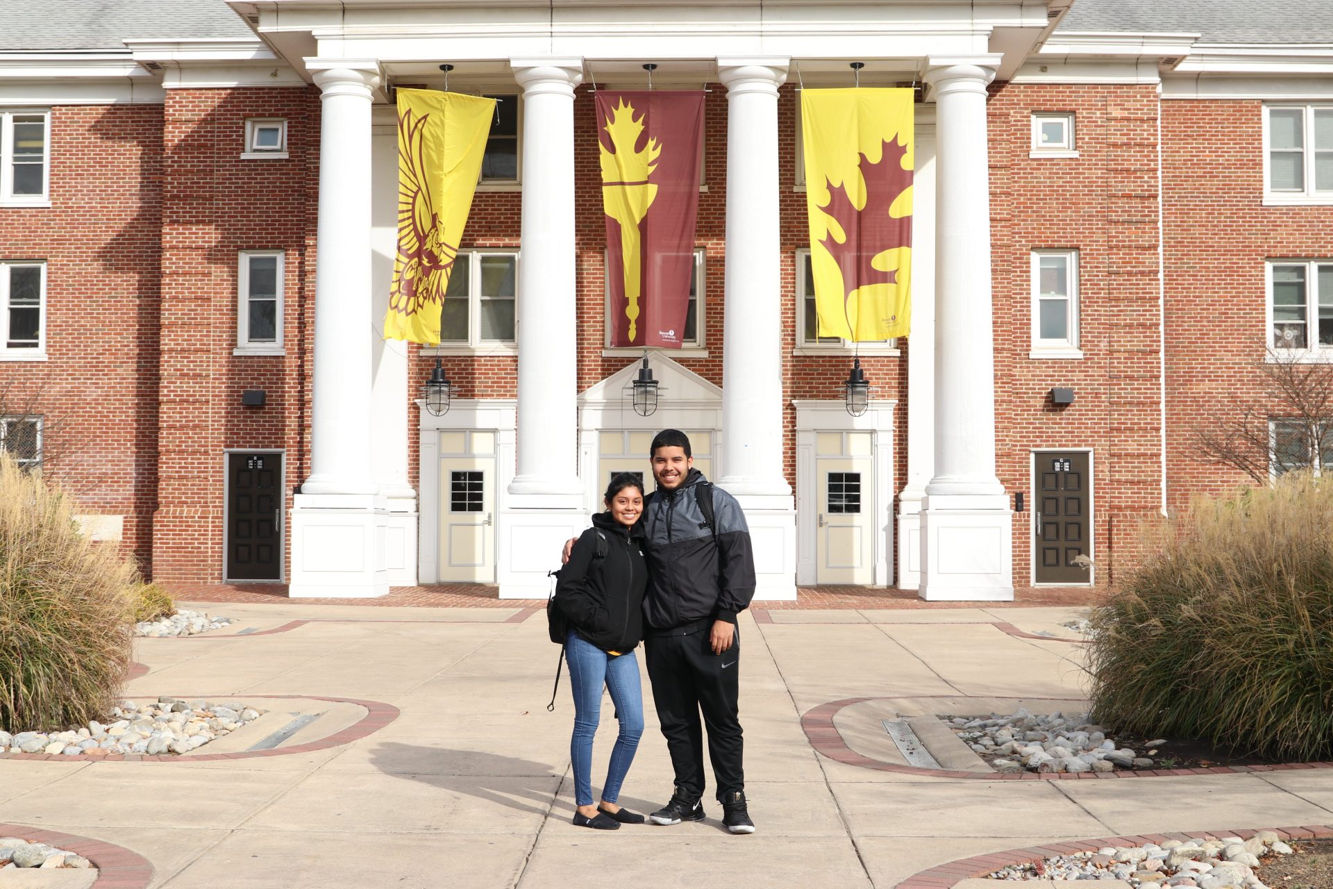 Two sophomore students stand proudly in front of Chestnut Hall.