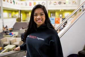 Nikki in the Rowan University student center wearing her Student University Programmers hoodie 