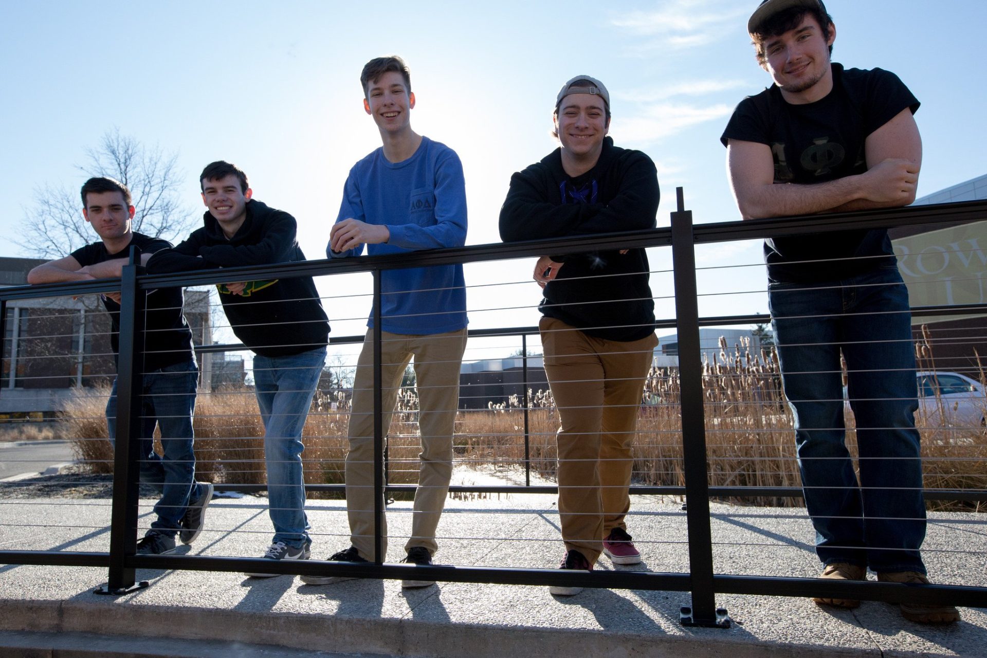 four APD brothers stand with arms over a bridge railing