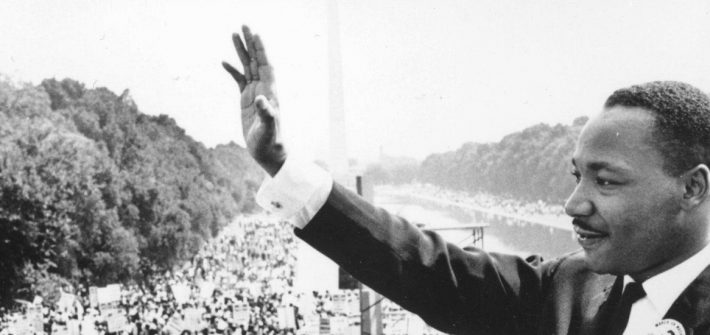 iconic photo of Dr. Martin Luther King waving at crowd after a speech