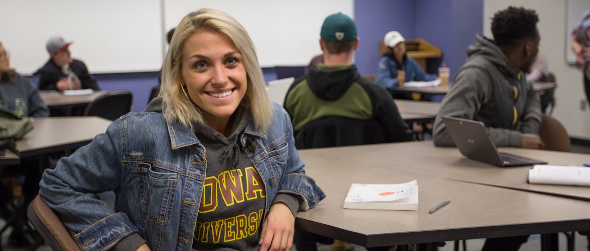 vanessa sitting in a college of communication and creative arts classroom