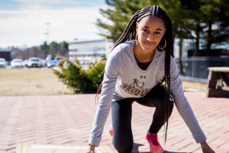 Sidney in track pose outside the track field at Rowan