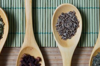 four wooden spoons hold spices