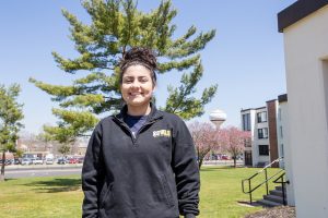 Student stands outside of Evergreen Hall at Rowan University