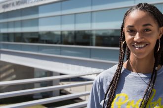 Sidney stands on the outside balcony of the new engineering building at Rowan University