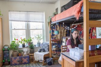 Noel sits at desk in her room in Willow Hall at Rowan University