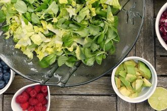 a table with plates of fresh veggies and salad on it