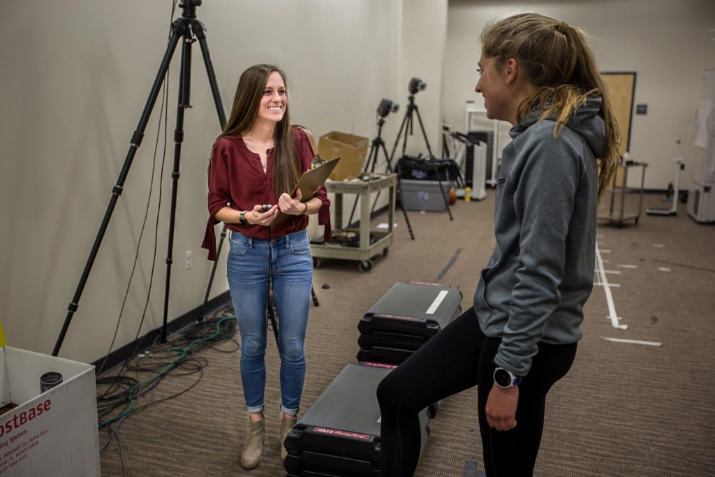 Female student performing pt exercises with another female student