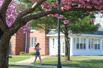 rowan university student walking outside willow hall during spring time