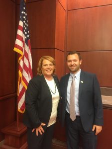 Rowan University's Connor and North Dakota Senator Heidi Heitkamp stand in front of an American flag in an office with wood panel walls
