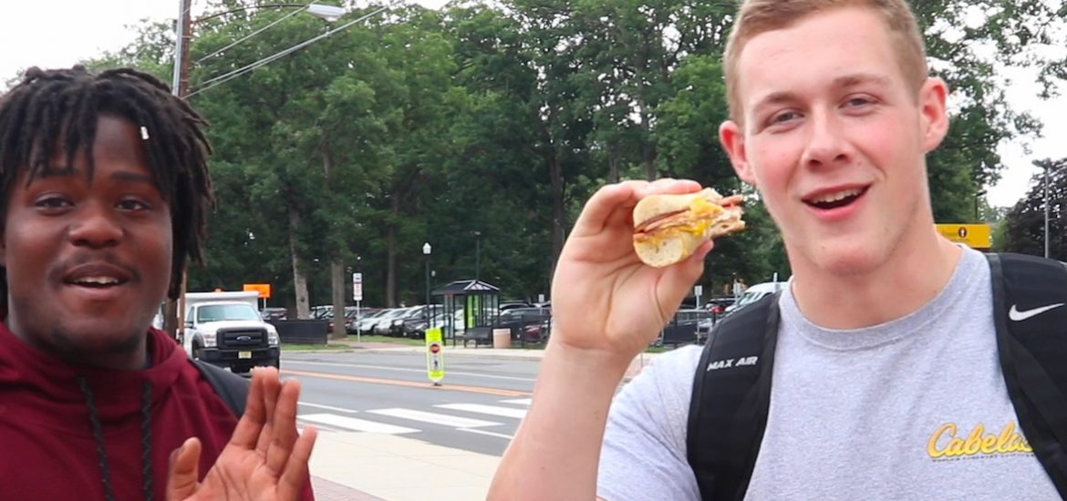 Two Rowan University Students eating a pork roll sandwich