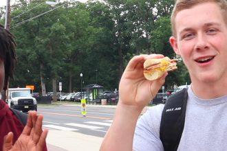 Two Rowan University Students eating a pork roll sandwich