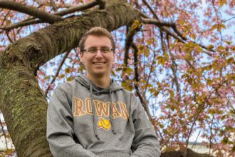 Rowan Alum Scott Timko in a tree with pink flowers