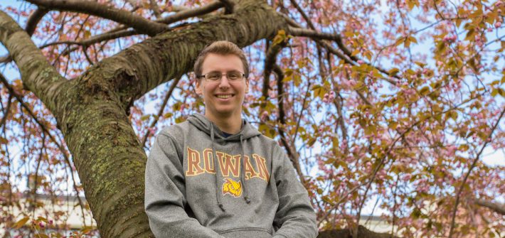 Rowan Alum Scott Timko in a tree with pink flowers