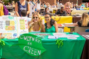 two female students sitting at the vegan booth at the club fair