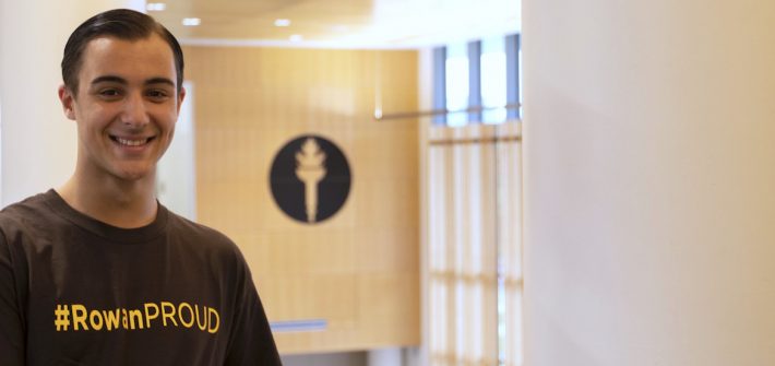 Dan Ryan wearing a #RowanProud shirt standing upstairs at business hall