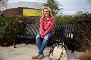 Kylie sitting on bench outside Rowan Wilson Hall 