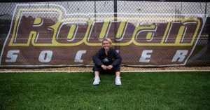 Kylie outside on soccer field in front of Rowan Soccer sign 