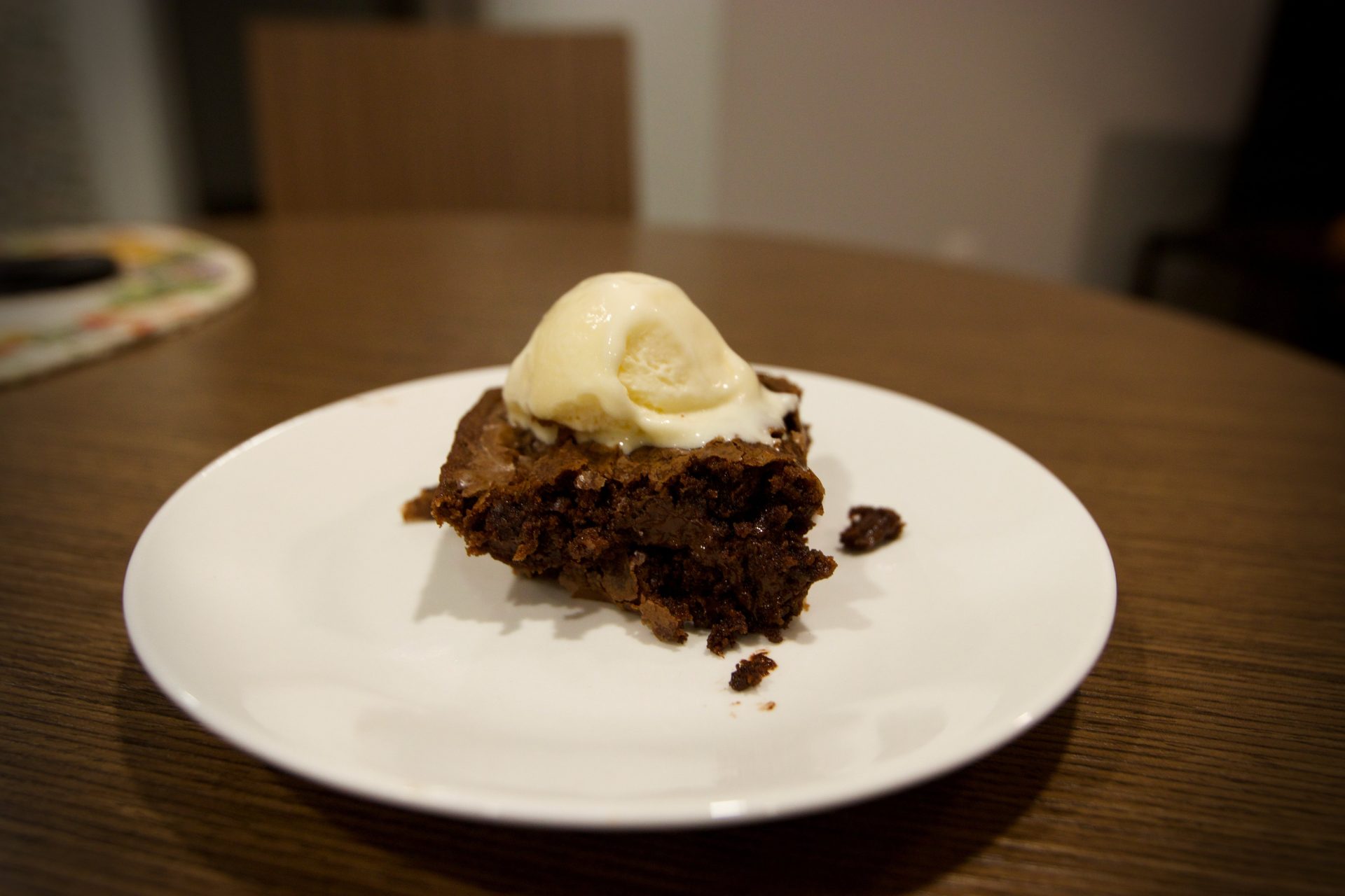 Up-close shot of baked brownie topped with ice cream.