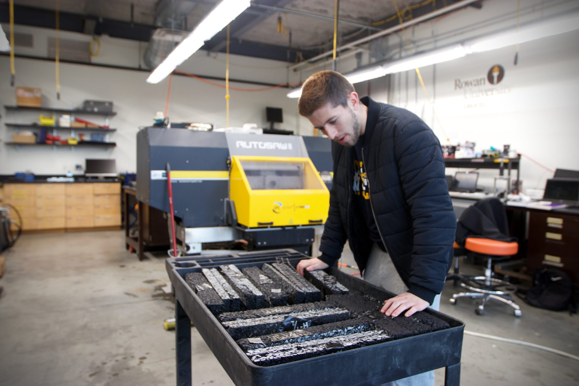 Rowan student, Joe Cerasi, looking over a table full of cement blocks at the Tech Park.