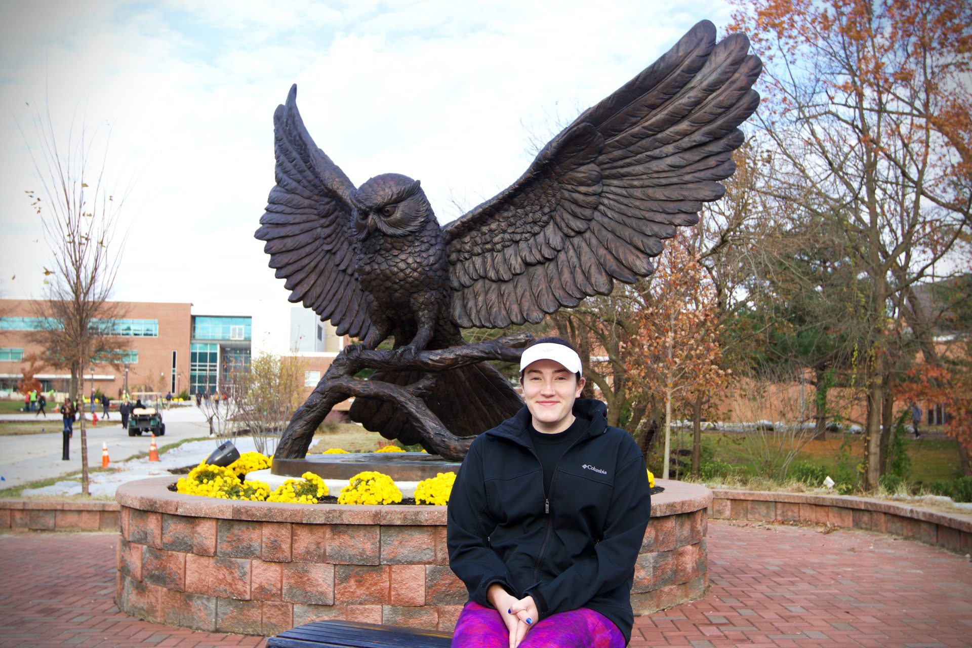 Meghin Rollins posing in front of Rowan's Prof statue outside of Robinson Hall.