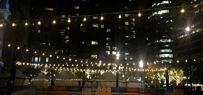 Photo of string lights above City Halls ice skating rink.