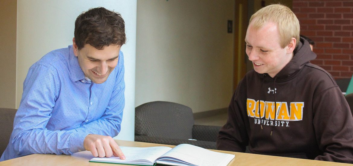Analytical chemist James Grinias at Rowan University sits with a student