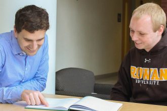 Analytical chemist James Grinias at Rowan University sits with a student