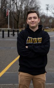 arms crossed, DJ standing outside in Rowan Engineering hoodie 