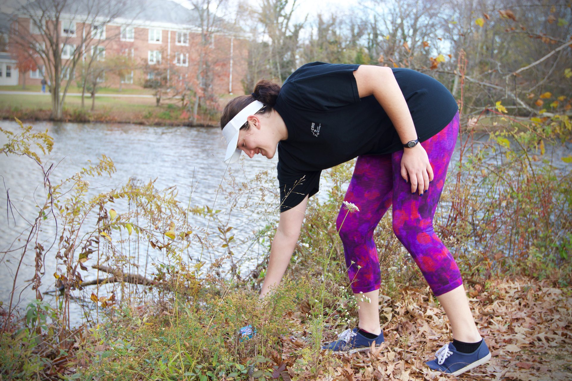 Meghin Rollins collecting trash surrounding the Chestnut Hall lake.