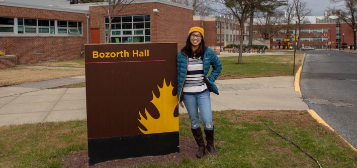 Student Jessica outside Bozorth Hall sign at Rowan University at Glassboro