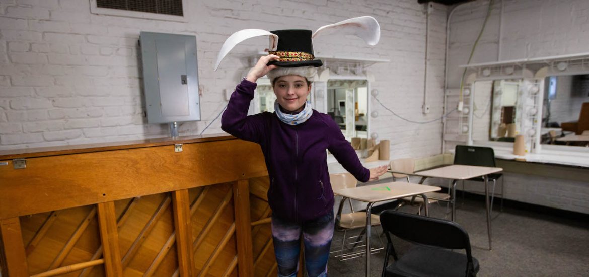 Student Isabel wearing a prop hat inside the rehearsal room