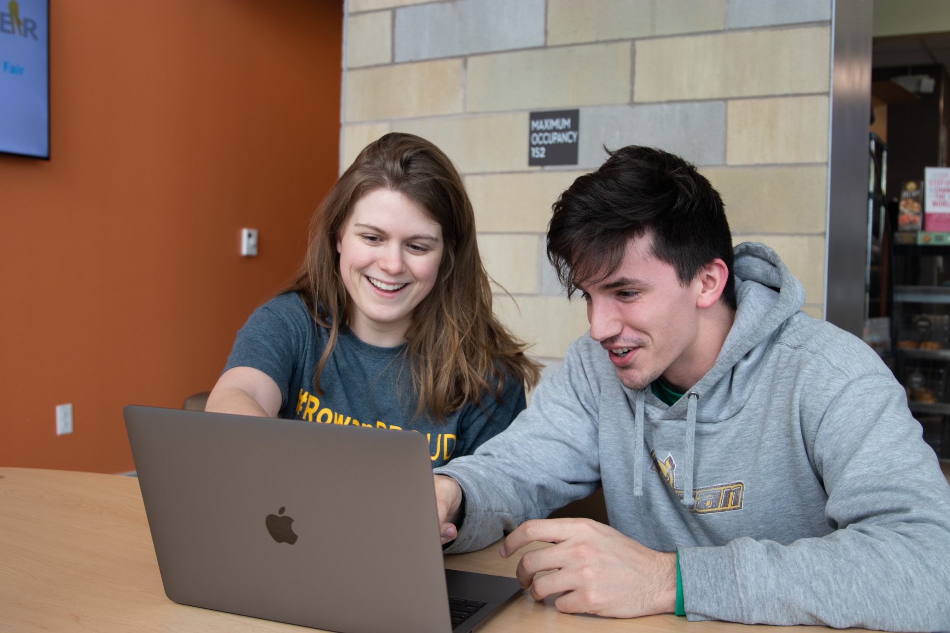 Morgan Dean showing Rowan student something on her laptop.