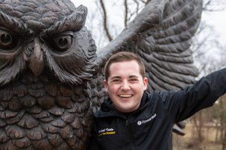 Mike at the owl statue outside Savitz with his hands up!