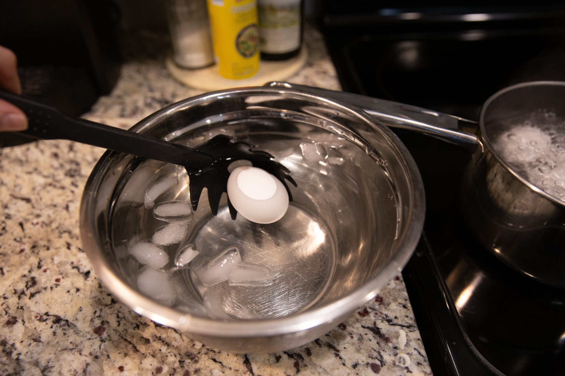 Boiled egg being dropped in ice water.