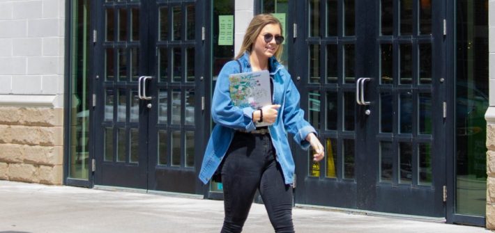Shaylin Heller, public relations major at Rowan University, walks past the book store holding her laptop and wearing sunglasses
