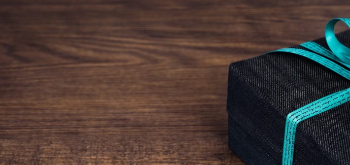 A blue and black present sitting on a wooden table